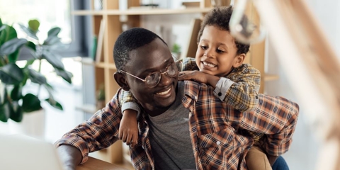 father spending time with son and working with laptop