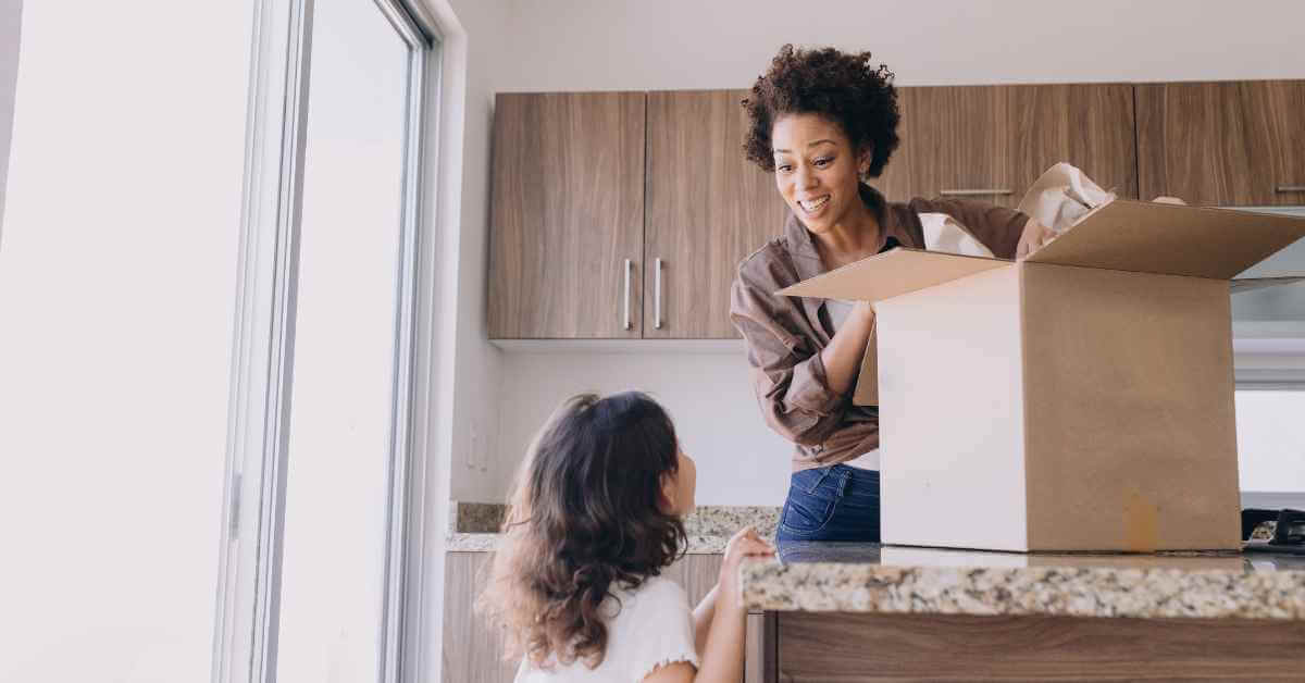 A mom packing a box while her daughter looks at her
