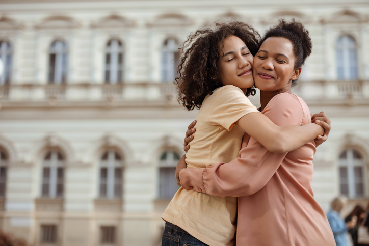 mother hugging teenage daughter