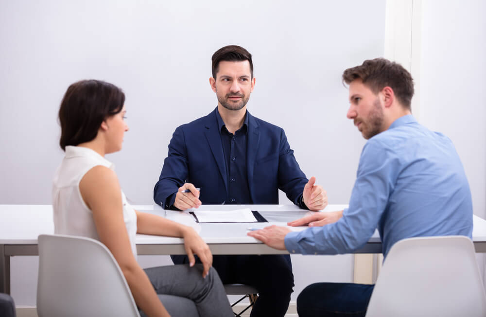 Rear View Of A Couple Sitting In Front Of Judge